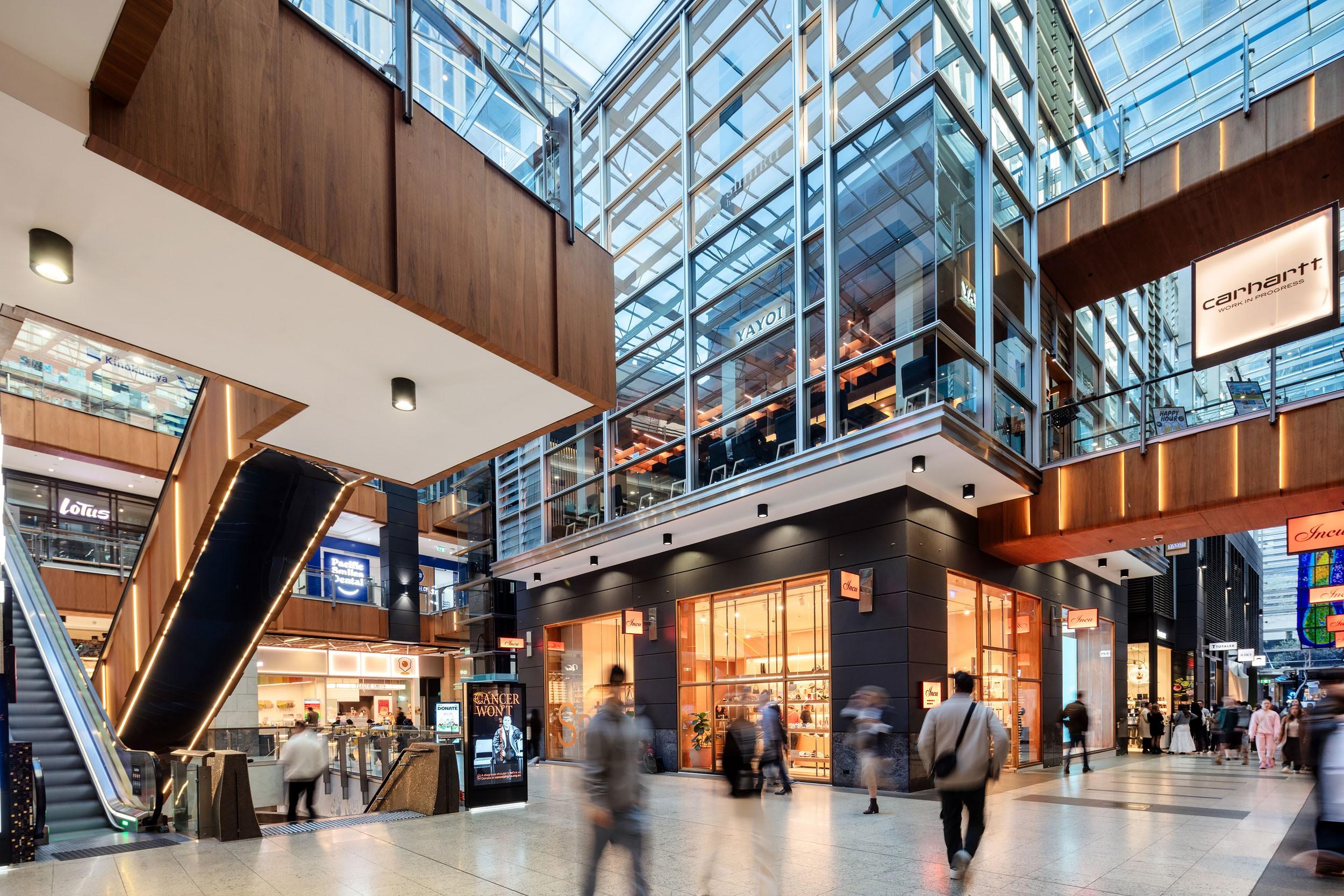 Large modern shopping centre atrium with escalators between floors