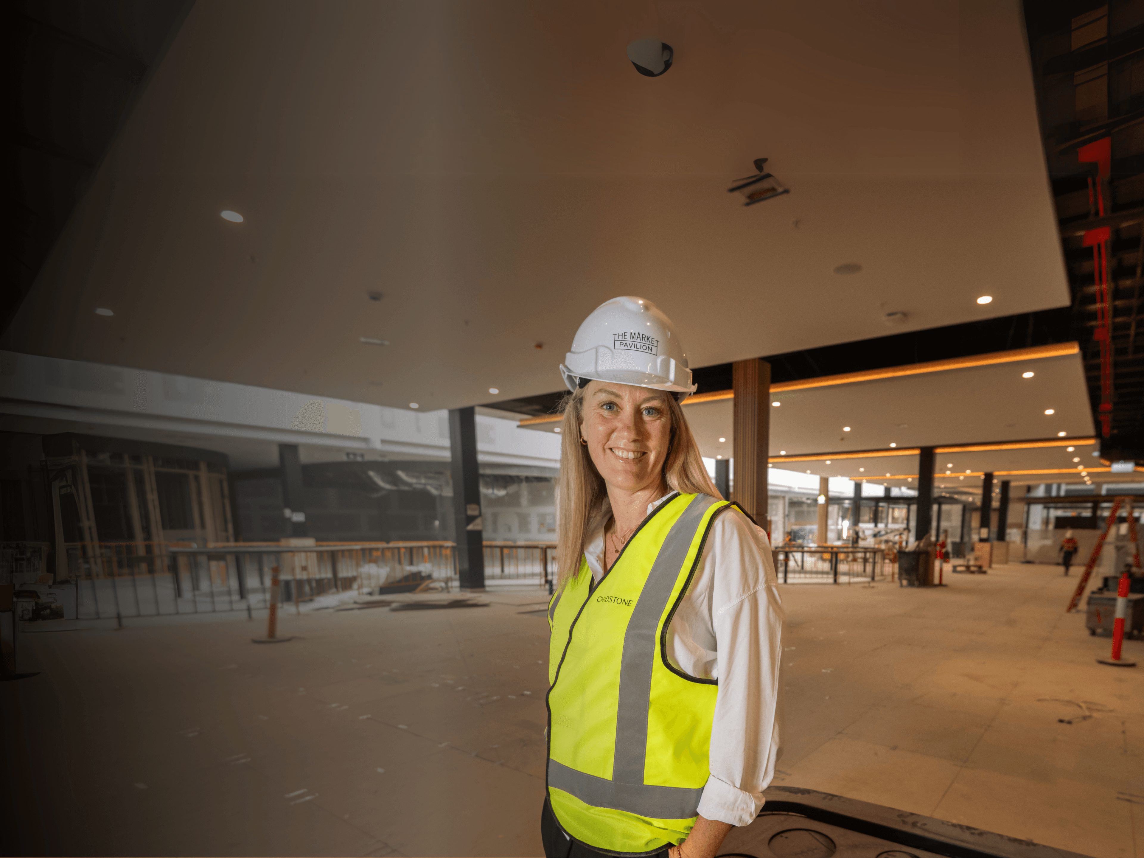 Renee Blome stands in a development site with a high vis vest and hard hat
